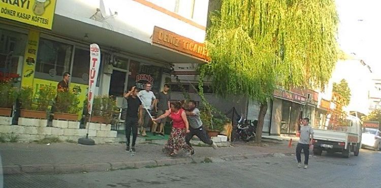 Eli sopalı kadın önüne gelen erkeği dövdü